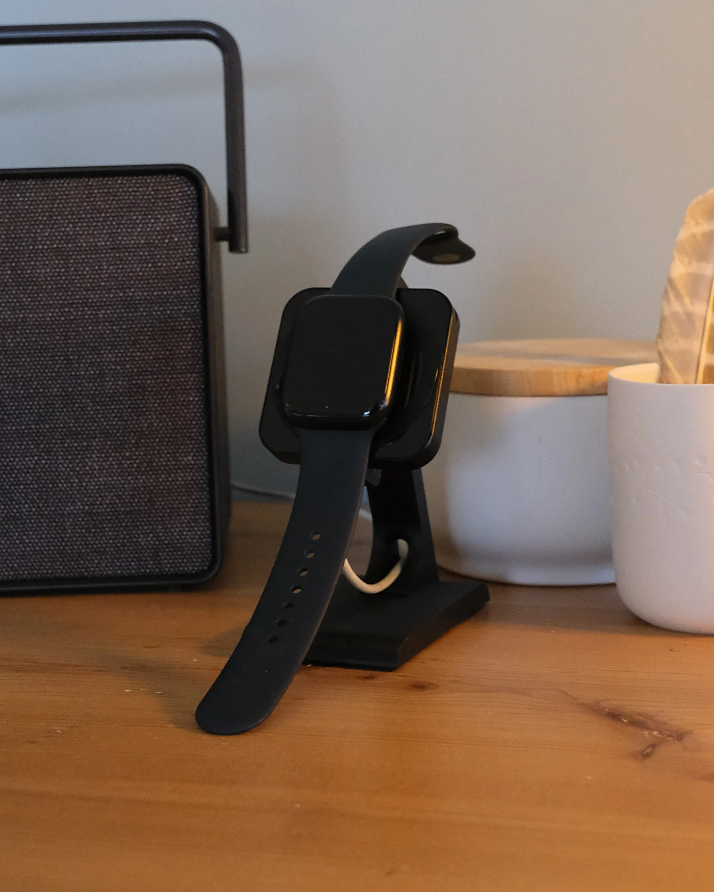 Apple Watch charging on the Klune HPER stand, on a wooden sideboard