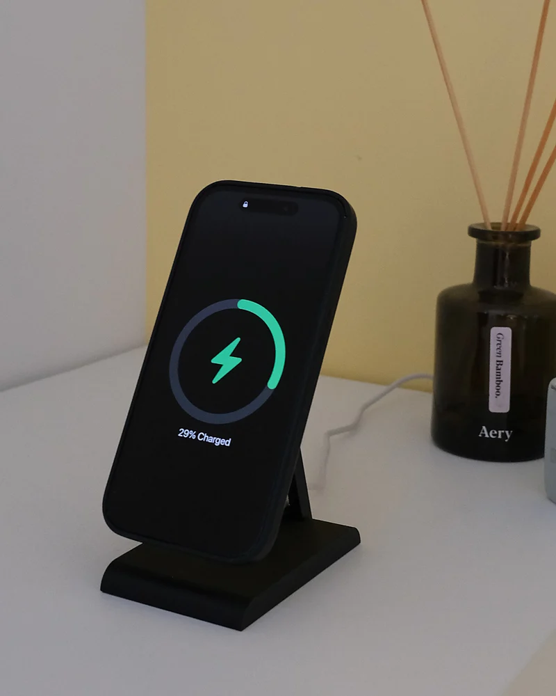 iPhone lädt auf dem HPER, auf einem weissen Möbel neben einem Diffusor